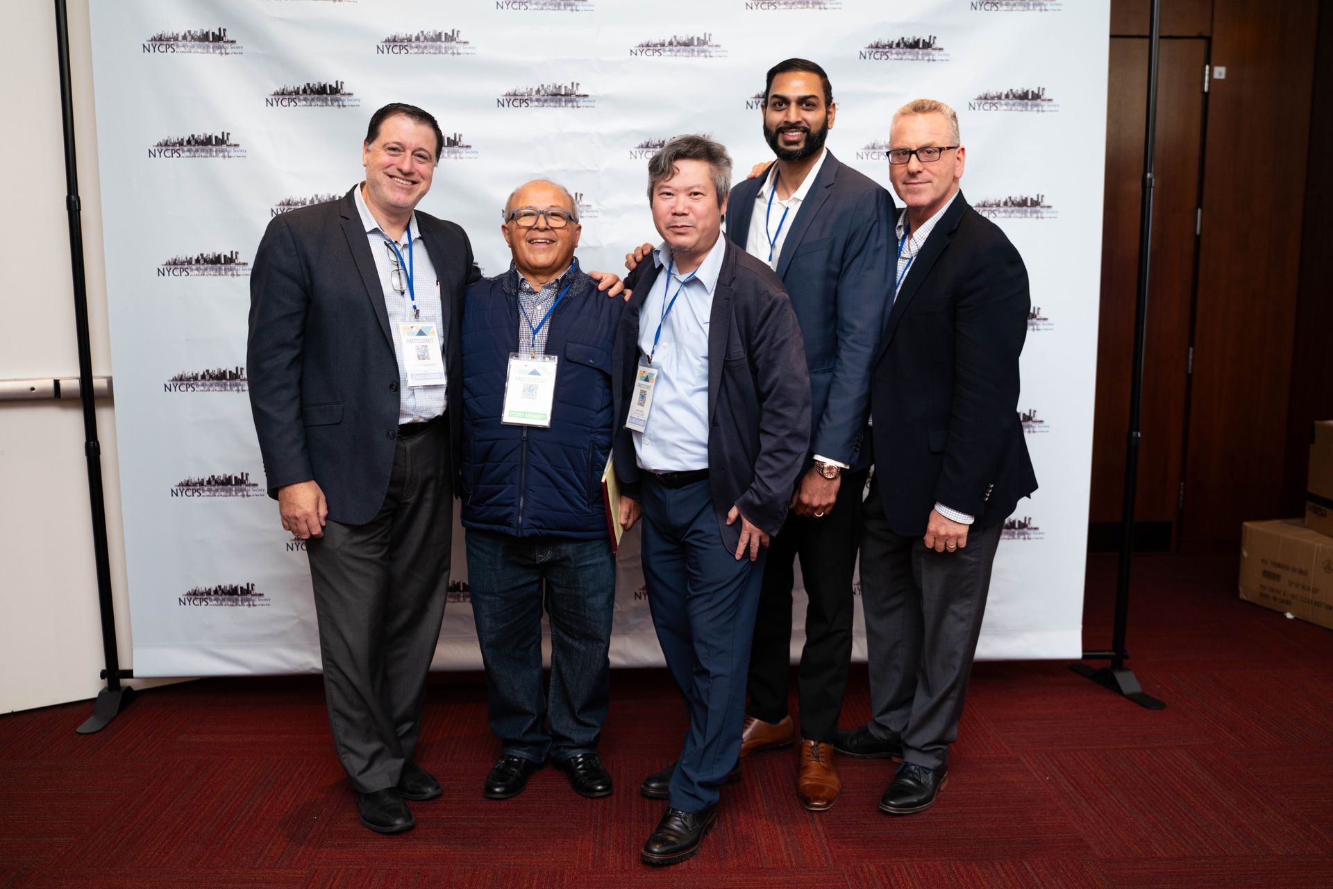 Group of colleagues posing in front of the photo wall